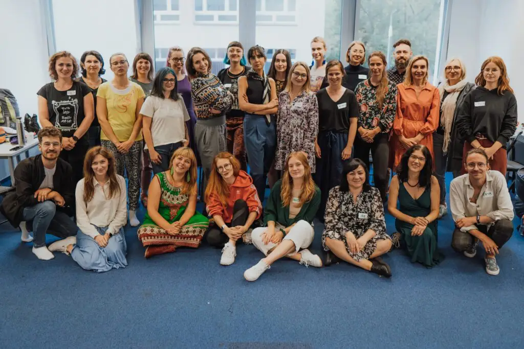 Zdjęcie grupowe kilkudziesięciu osób będących członkami i członkiniami zespołu Stowarzyszenia Mudita